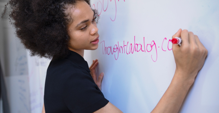 Girl writing on a whiteboard in a brainstorm session